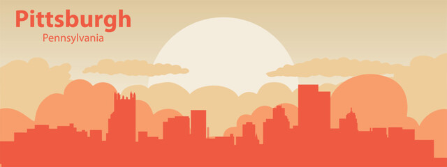 the silhouette of the city of Pittsburgh, Pennsilvania against the backdrop of the sunset with clouds in the sky.