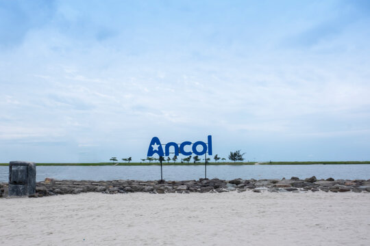 Jakarta, Indonesia - March 15, 2025: Ancol signage and logo type with a blue skyline as a background and white sand as a foreground.