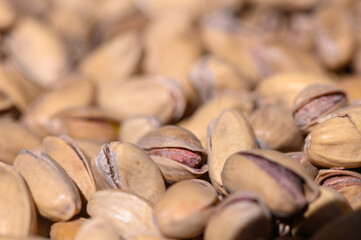 Pistachio nuts in natural light highlight their texture and unique shells amid a warm, inviting setting at a local market