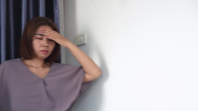 asian woman feeling tired and dizzy from anemia, suddenly experiencing vertigo, headache, and trouble balancing, possibly due to low iron, heat stroke, or blood circulation problems