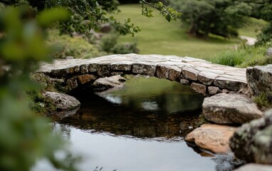 Fototapeta premium Stone Bridge Over Calm Stream in Lush Garden
