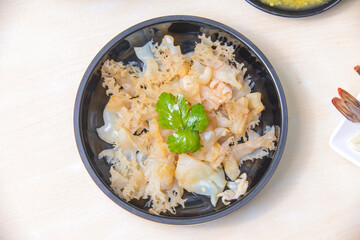 Jellyfish Salad with sesame oil and roasted chilli-in-oil paste on the black dish.