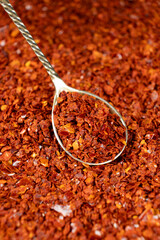 Crushed red hot chili pepper natural seasoning in a spoon