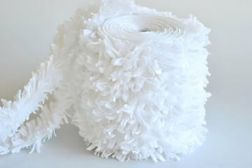 White fluffy fabric trim roll, craft supply, studio background