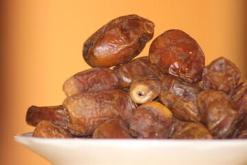 A close-up shot of healthy brown dates on a white plate