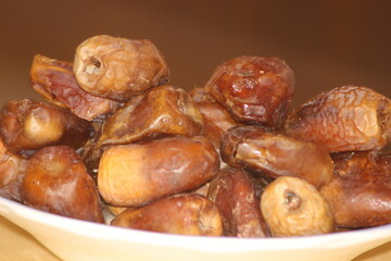 A close-up shot of healthy brown dates on a white plate