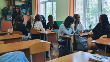 Classroom socialization, teenagers and their teacher engaging in conversations and bonding during break time