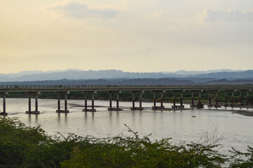 Fototapeta premium lake in the morning, Turbat city river bridge Baluchistan. Landscape nature cloudy sky mountain background