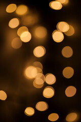Golden Bokeh Lights: A Warm and Abstract Display of Blurred Circles, Capturing the Soft Glow and Dreamy Atmosphere of Out-of-Focus Illumination Against a Dark Background
