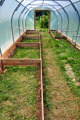 Polytunnel under construction - Staging supports connected polytunnel hoops and vegetable beds being constructed in situ
