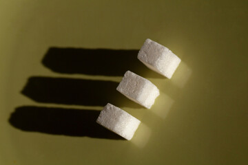 Three Sugar Cubes: A Minimalist Composition of White Cubes Casting Long Shadows on a Green Surface, A Study in Simple Geometry and Light Play