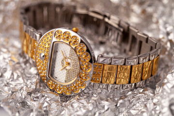 Gold and Silver Ladies Watch: A Close-Up of Luxury Timekeeping, Diamond Accents on a Textured Background, Capturing the Glamour and Sophistication of a Designer Wrist Accessory in a Detailed Shot
