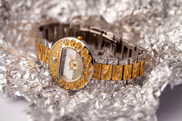 Gold and Silver Ladies Watch: A Close-Up of Luxury Timekeeping, Diamond Accents on a Textured Background, Capturing the Glamour and Sophistication of a Designer Wrist Accessory in a Detailed Shot