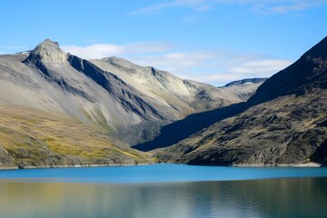 Serene water, rocky mountains, and blue sky create a peaceful vista