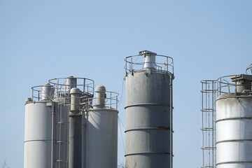 Silosy cementowni z widocznymi drabinami pionowymi