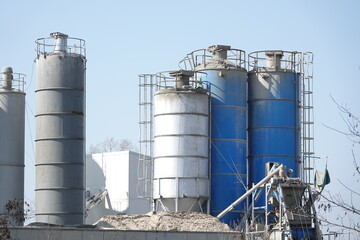Silosy cementowni z widocznymi drabinami pionowymi