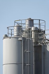 Silosy cementowni z widocznymi drabinami pionowymi