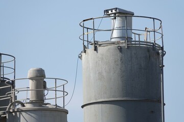 Silosy cementowni z widocznymi drabinami pionowymi