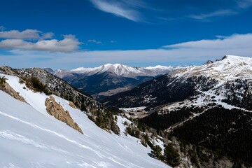 Obraz premium Snowy mountain range view under a clear blue sky with light clouds