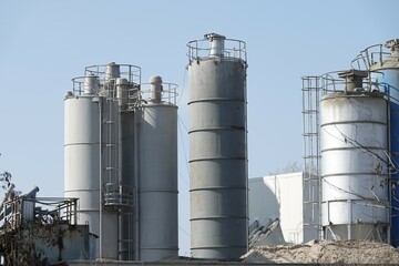 Silosy cementowni z widocznymi drabinami pionowymi