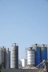 Silosy cementowni z widocznymi drabinami pionowymi