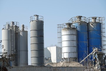 Silosy cementowni z widocznymi drabinami pionowymi