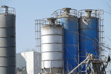 Silosy cementowni z widocznymi drabinami pionowymi