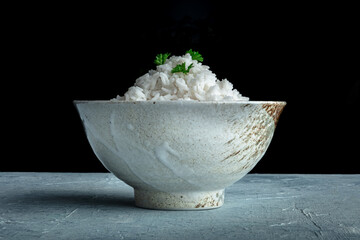 White rice, cooked. A bowl of boiled long grain rice, a simple side dish, side view