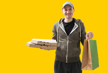 Paper pocket and food containers in hands of a smiling deliveryman. Quality service of a restaurant.