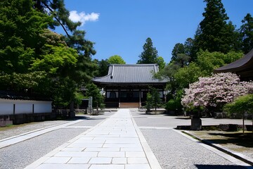Fototapeta premium Tranquil temple path through green trees under a blue sky