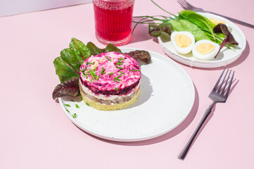 Salad with herring and beets in a plate. Salad Herring under a fur coat