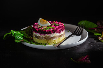 Salad with herring and beets in a plate. Salad Herring under a fur coat