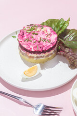 Salad with herring and beets in a plate. Salad Herring under a fur coat