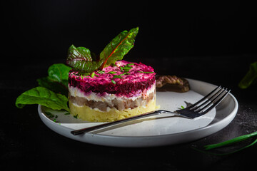Salad with herring and beets in a plate. Salad Herring under a fur coat