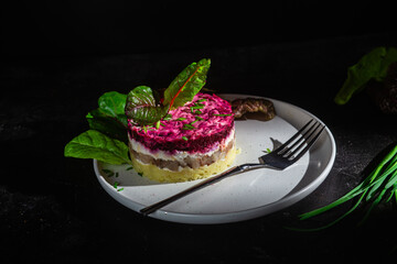 Salad with herring and beets in a plate. Salad Herring under a fur coat