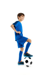 Cute young boy soccer player, in blue sport outfit holding leg on classic soccer ball
