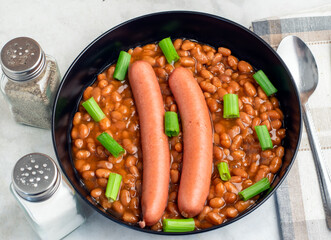 hot dogs  on baked beans top with green onions