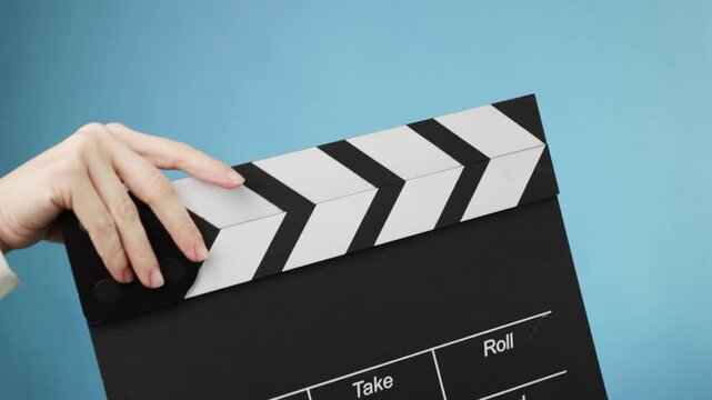 Studio production closeup, hands using a blackboard clap, beginning a filmmaking process
