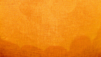 A close-up photograph showcasing the rich, vibrant texture of gold velvet fabric with a subtle gradient, suitable for use as a luxurious background or design element. yellow fabric texture.
