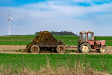old wooden cart, wooden cart hitched to an old antique farm tractor in a field on a beautiful sunny...