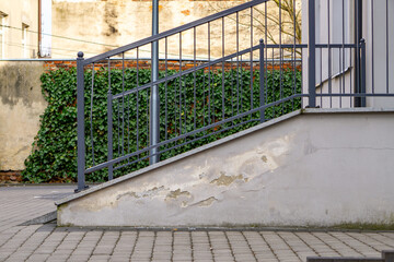 peeling plaster from external stairs due to moisture. metal balustrades of entrance stairs to the...