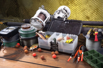 Fishing items laid out on a table against a wooden, old background.