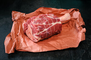 Beef Hammer, Rinderhaxe, Rinderwade, roh, gekn&uuml;pft, auf Butcher Paper, Metzgerpapier, auf schwarzem Schiefer