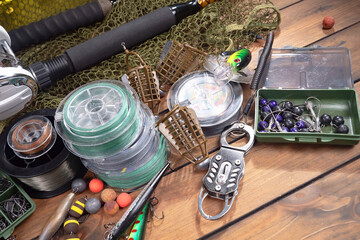 Fishing items laid out on a table against a wooden, old background.