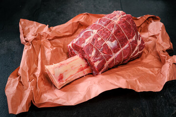 Beef Hammer, Rinderhaxe, Rinderwade, roh, gekn&uuml;pft, auf Butcher Paper, Metzgerpapier, auf schwarzem Schiefer