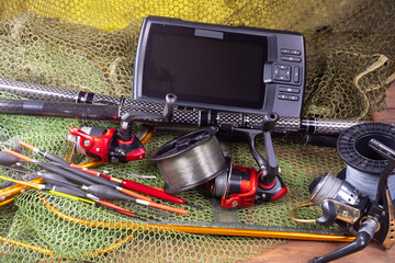 Sport fishing equipment on a table in a studio in a composition, against a wooden background and a fishing net.