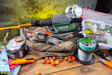 Fishing items laid out on a table against a wooden, old background.