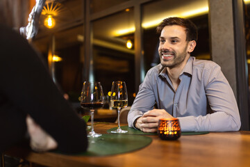Couple on a romantic dinner date at the restaurant. They drink wine.