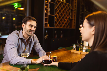 Couple on a romantic date. They drink wine and hold hands.