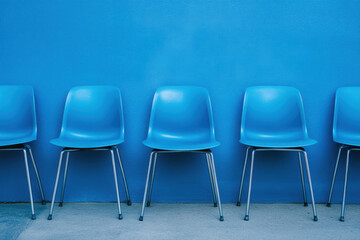 Obraz premium A single blue chair stands out against a sea of similar chairs, symbolizing uniqueness and success